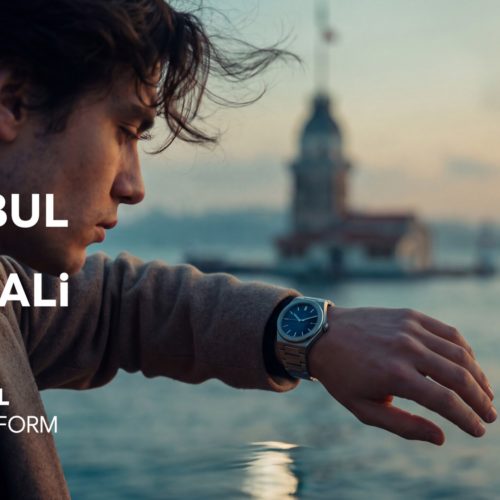 Campaign visual: a man checks his watch with the Maiden's Tower in the background